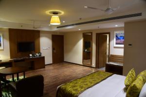 a hotel room with a bed and a desk at Lemon Tree Hotel Siliguri in Siliguri
