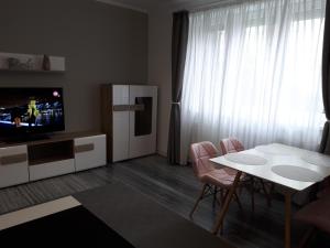 クルジュ・ナポカにあるCarla's Residenceのリビングルーム(テーブル、白い冷蔵庫付)