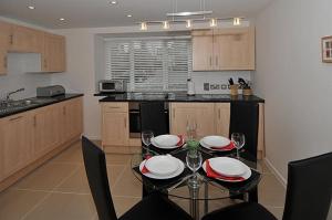 a kitchen with a dining table with plates and wine glasses at HomefromHolme Christchurch Close in St. Albans