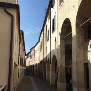een steegje in een gebouw waar een persoon doorheen loopt bij Little Garden in Treviso