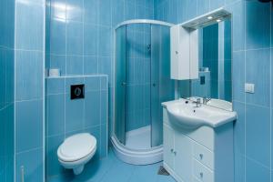a blue bathroom with a toilet and a sink at Panorama lux apartment in Rogoznica +28 photos