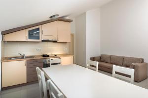 a kitchen and living room with a table and a couch at Panorama lux apartment in Rogoznica