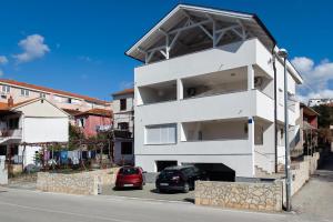 a white building on the side of a street at Panorama lux apartment in Rogoznica