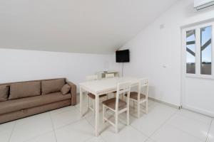 a living room with a table and a couch at Panorama lux apartment in Rogoznica