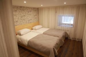 two beds in a small bedroom with a window at WINE & ROSE BOUTIQUE HOTEL in Kharkiv