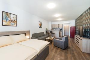 a bedroom with a bed and a living room at Barok Hotel and Apartments in Bratislava