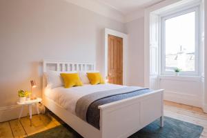 Giường trong phòng chung tại Historic Edinburgh 1890s Home Turned Relaxing Retreat