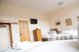 sypialnia z dwoma łóżkami i telewizorem na ścianie w obiekcie Gradbach Mill B&B w mieście Buxton