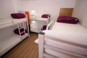 a room with three bunk beds in a dorm at Albergue Lalin Centro in Lalín