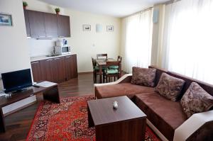 una sala de estar con un sofá y una mesa en GT Aspen House Apartments, en Bansko