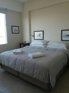 a bedroom with a large bed with towels on it at Departamento moderno centrico, vista ciudad, valle y montañas in Salta