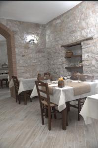 uma sala de jantar com mesas e cadeiras e uma parede de pedra em Agriturismo Il Parco em Nusco
