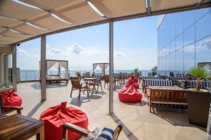 a patio with tables and chairs and a view of the ocean at Silver Beach Apart Complex in Byala