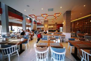 a restaurant with wooden tables and chairs and people in it at Sey Beach Hotel & Spa in Alanya