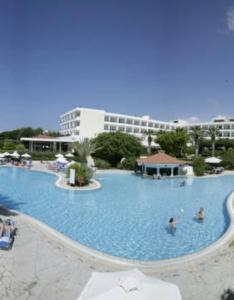 una grande piscina con persone in acqua di Avanti Hotel a Paphos