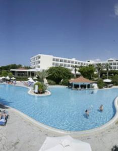 a large swimming pool with people in the water at Avanti Hotel in Paphos
