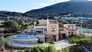 a house with a swimming pool in front of a mountain at Ida villa in Hersonissos