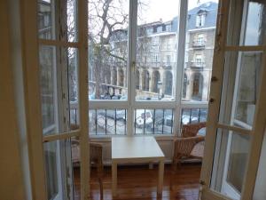 uma janela aberta com uma mesa e vista para um edifício em Hostal del Arquitecto em Vitoria-Gasteiz