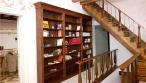 a book shelf next to a staircase with books at Ca' del Cafetier in Venice