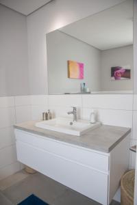 ein Badezimmer mit Waschbecken und Spiegel in der Unterkunft Turmalin Cottage Unit 1 in Swakopmund