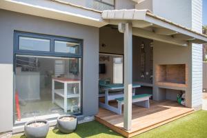 un patio avec une table et un banc sur une terrasse dans l'établissement Turmalin Cottage Unit 1, à Swakopmund