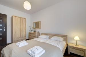 a bedroom with two beds with towels on them at Dom & House - Apartamenty Aquarius in Sopot