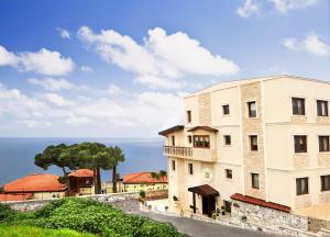 a building with the ocean in the background at Bulbul Yuvası Boutique Hotel in Foça