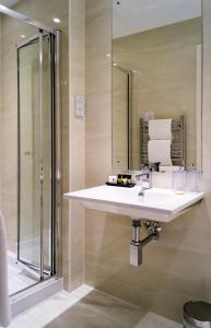 La salle de bains est pourvue d'un lavabo et d'une douche. dans l'établissement Rising Sun Hotel, à Lynmouth