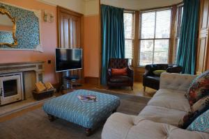 a living room with a couch and a tv at Invermay in Blairgowrie