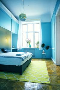 een blauwe slaapkamer met een bed en een raam bij 4th Floor Bed and Breakfast in Warschau