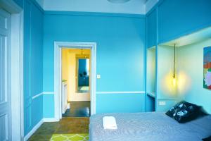 niebieski pokój z łóżkiem i lustrem w obiekcie 4th Floor Bed and Breakfast w Warszawie