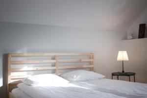 a bedroom with a bed with white sheets and a lamp at Święty Spokój in Radków