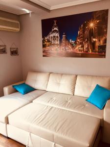 a white couch with blue pillows in a room at Apartments Madrid Principe in Madrid