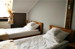 - une chambre avec 2 lits avec des draps blancs et une fenêtre dans l'établissement KUŹNIA SMAKU, à Krosno Odrzańskie