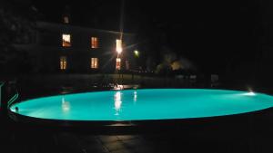 a large swimming pool with a light shining on it at La Chancellerie in Huismes