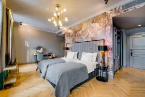 two beds in a bedroom with a floral wall at Grand Poet Hotel and SPA by Semarah in Rīga