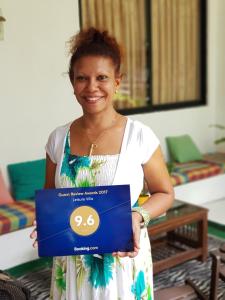 Uma mulher está a segurar uma caixa azul. em Leisure Villa em Colombo