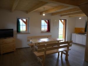 ein Esszimmer mit einem Tisch und 2 Bänken in der Unterkunft Chatki Niwki u Zbója in Krościenko nad Dunajcem