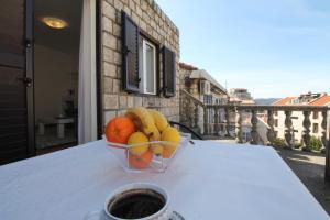 a bowl of fruit on a table with a cup of coffee at Luxury Apartment Stefan in Sveti Stefan