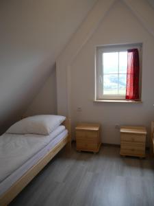 a bedroom with a bed and two night stands and a window at Chatki Niwki u Zbója in Krościenko