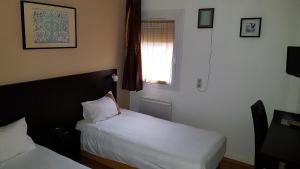 Postel nebo postele na pokoji v ubytování Hôtel d'Alsace