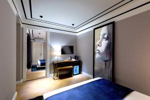 a bedroom with a large painting of a woman on the wall at Walton Hotels Galata in Istanbul
