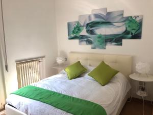 ein Schlafzimmer mit einem Bett mit zwei grünen Kissen in der Unterkunft dany holidays apartment in Florenz