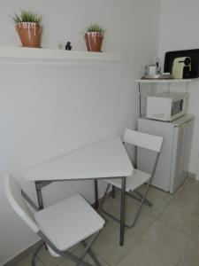 a white table and two chairs in a kitchen at iHome Apartment 4.0 in Pécs