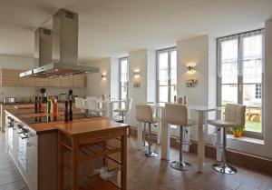 een keuken met witte stoelen en een keukeneiland bij Dreiseithof Sohra in Sohra