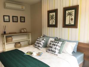 a bedroom with a bed with pillows and a book at rain condo Cha-am 2 bedroom by Napa in Cha Am