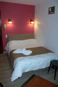 a bedroom with a bed with two white towels on it at Hotel restaurant MARTINEZ in Balaruc-les-Bains