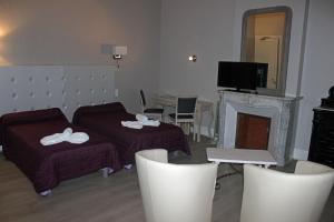a living room with a bed and a fireplace at Hotel restaurant MARTINEZ in Balaruc-les-Bains