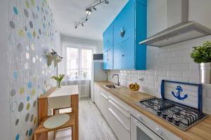 a kitchen with blue cabinets and a stove top oven at Pikachu's Gallery - historical old town Bratislava in Bratislava