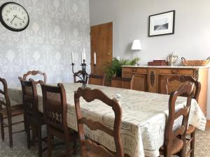a dining room with a table and chairs and a clock at Guillemont Halt in Guillemont